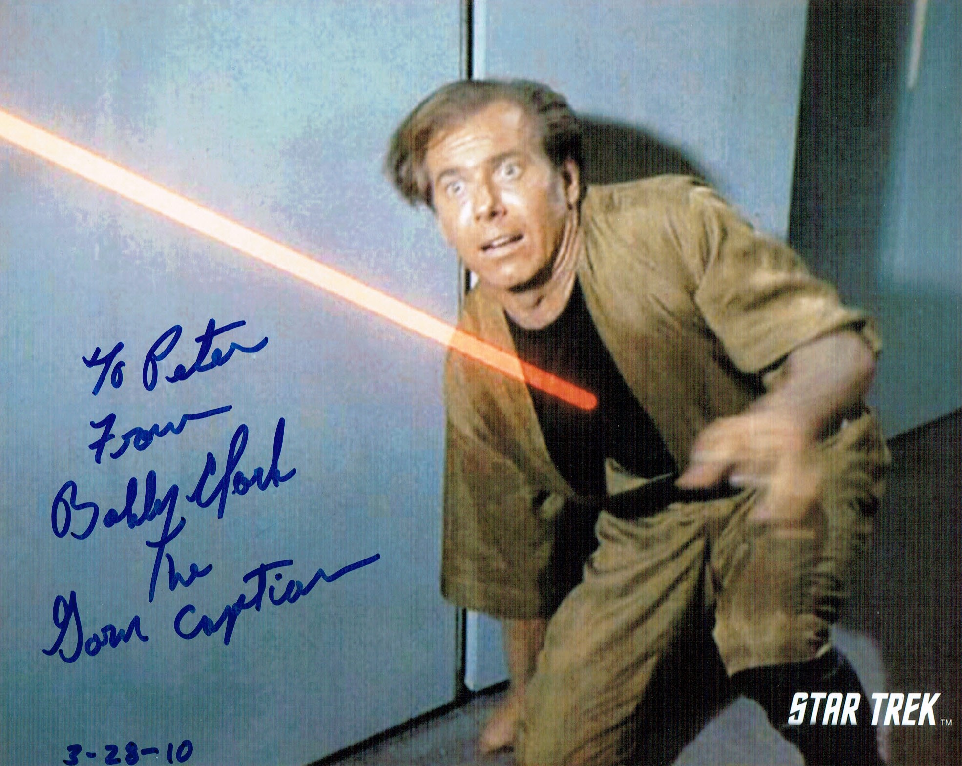 An 8x10 image from the Star Trek episode Mirror Mirror, showing Bobby Clark being hit by a phaser beam, and signed by Clark.