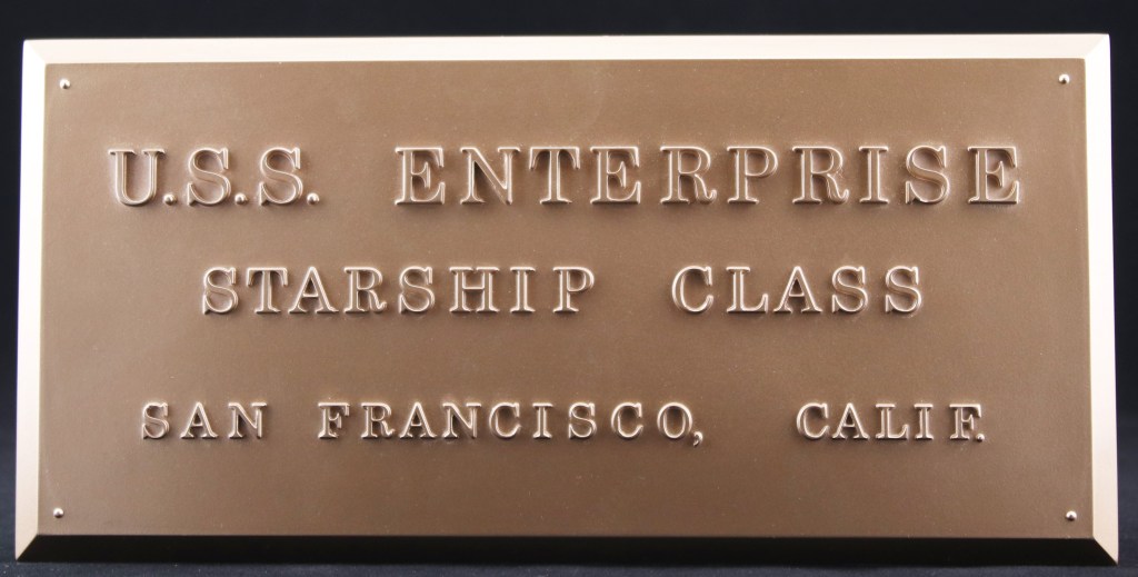 The Eaglemoss dedication plaque replica. It reads: USS Enterprise, Starship Class, San Francisco, Calif.